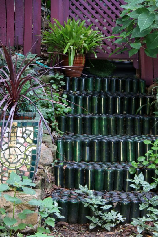 Stacked, upended bottles form steps at the back of the garden.