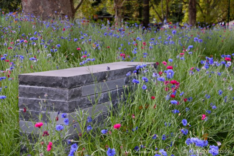 Stacked bluestone bench set amongst soft plantings.